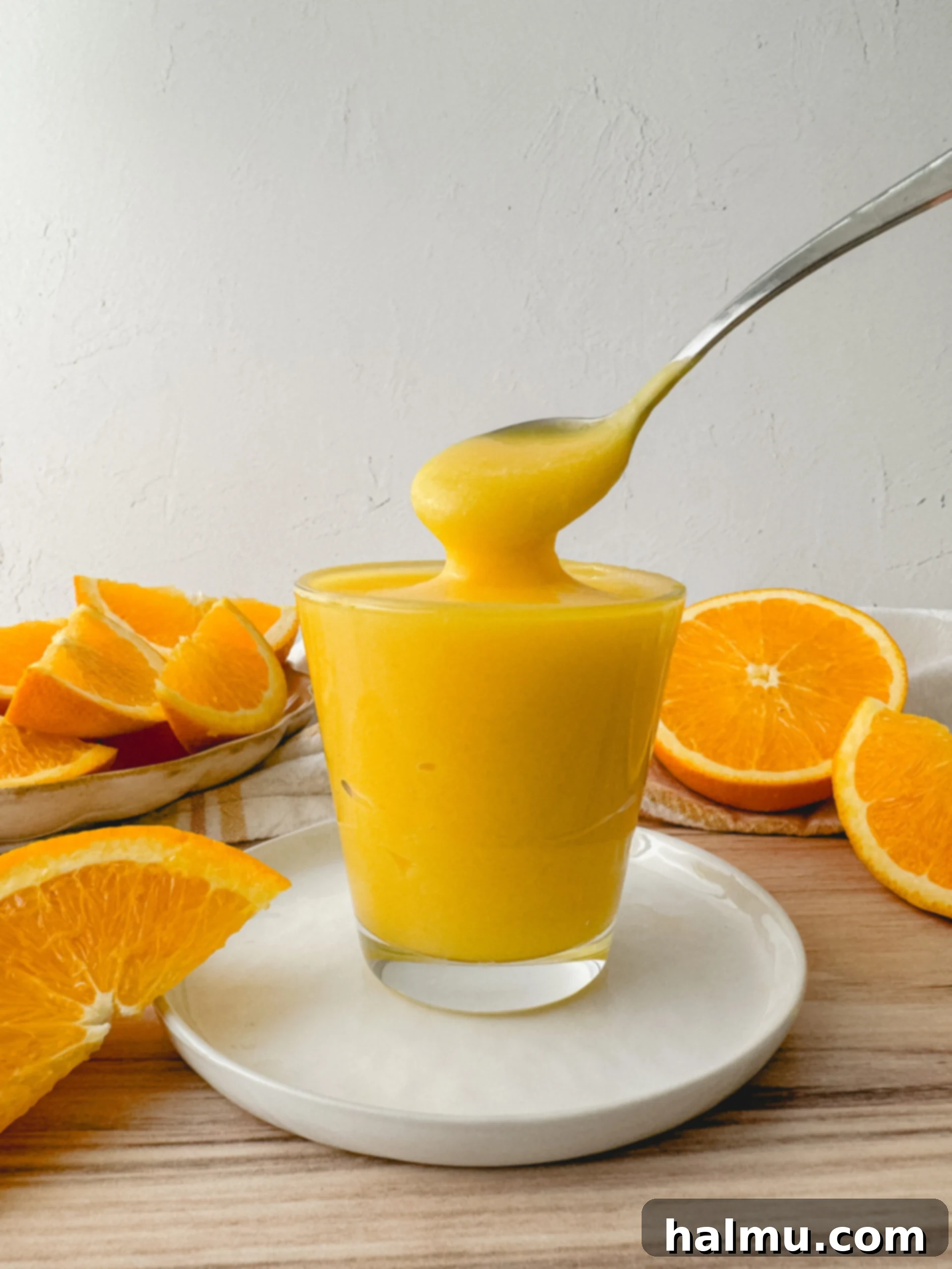 A stack of beautifully plated mini orange cheesecakes, highlighting the distinct layers of crust, filling, and orange curd.