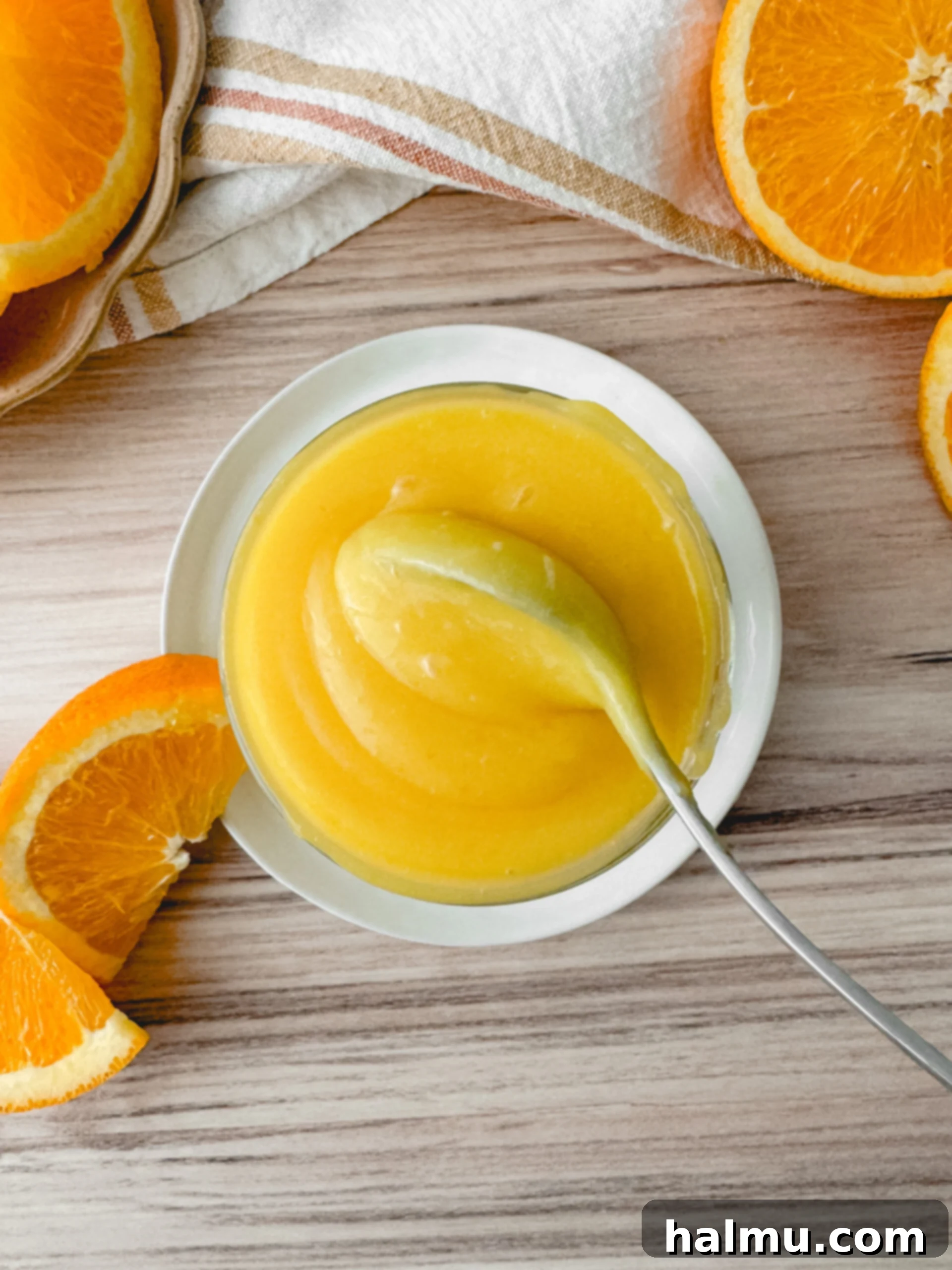 Ingredients for orange curd laid out on a kitchen counter, including oranges, lemons, eggs, and butter.