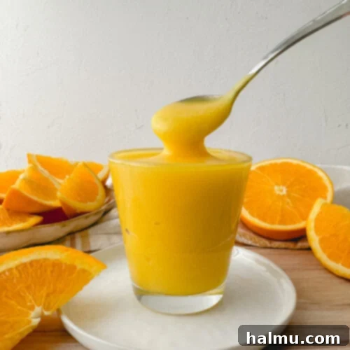 Orange Curd in a bowl with fresh oranges, ready to be served.