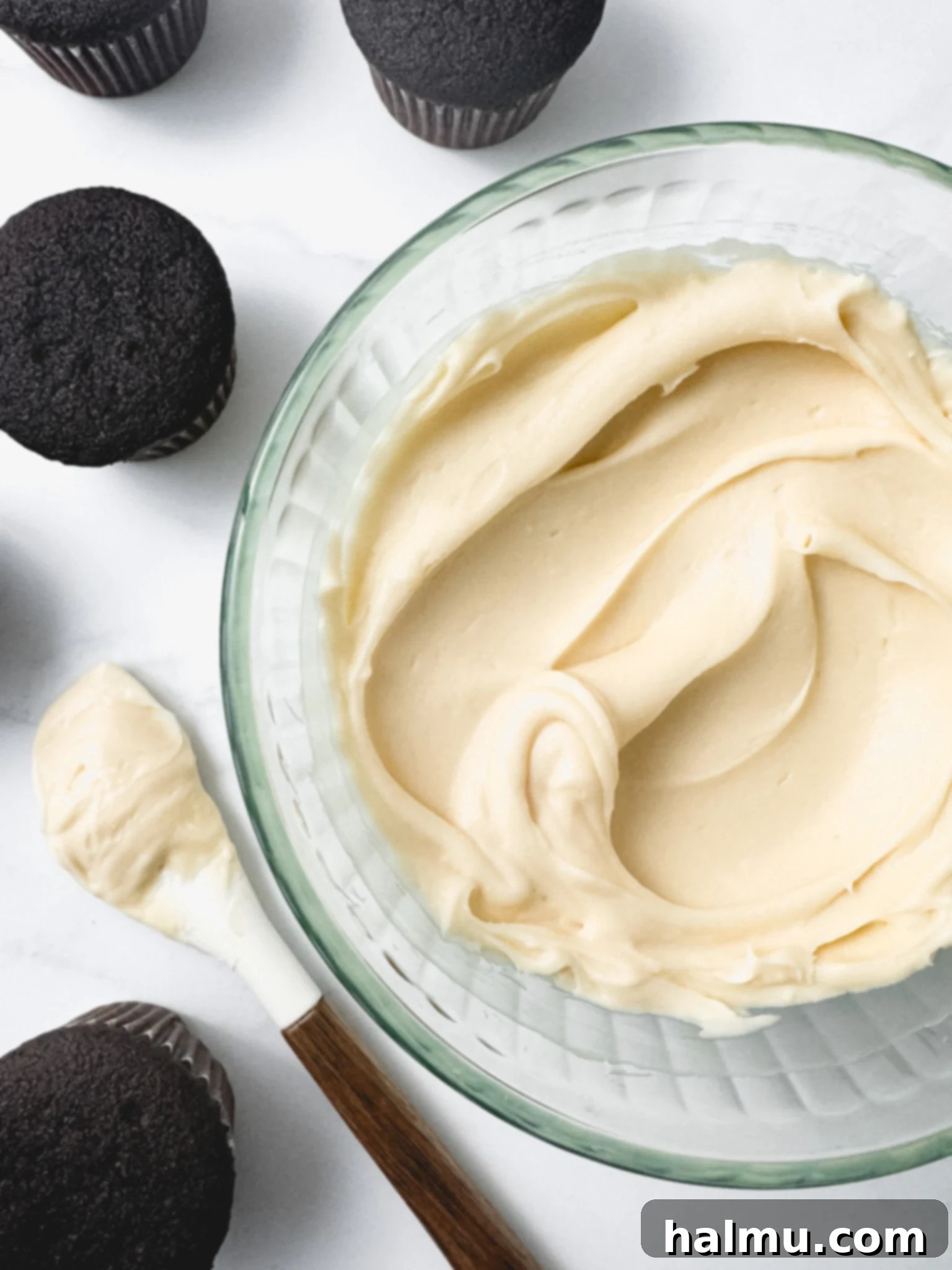 Close up of a piping bag filled with cream cheese frosting