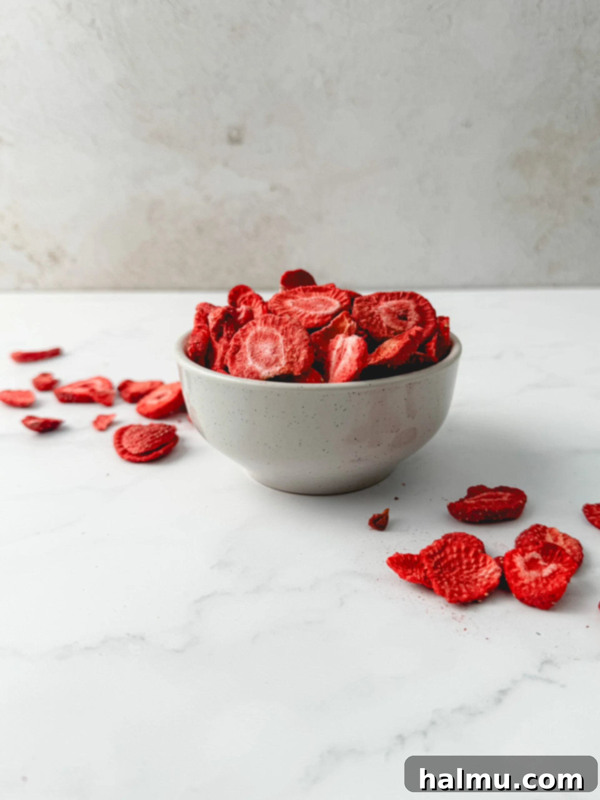 A bowl of vibrant pink freeze-dried strawberries, ready to be ground for buttercream.