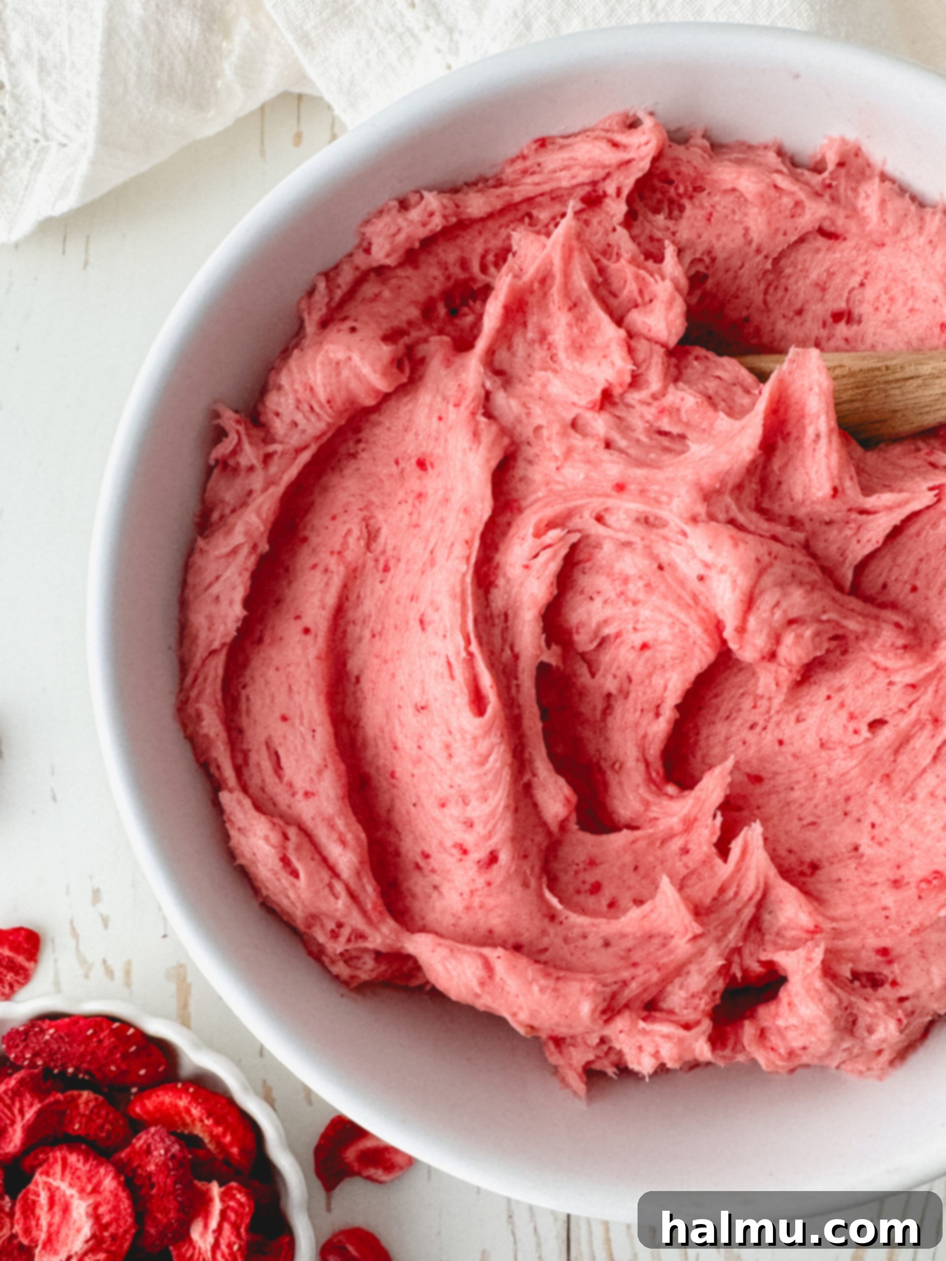 A plate of cupcakes beautifully frosted with strawberry buttercream, showcasing the smooth texture.