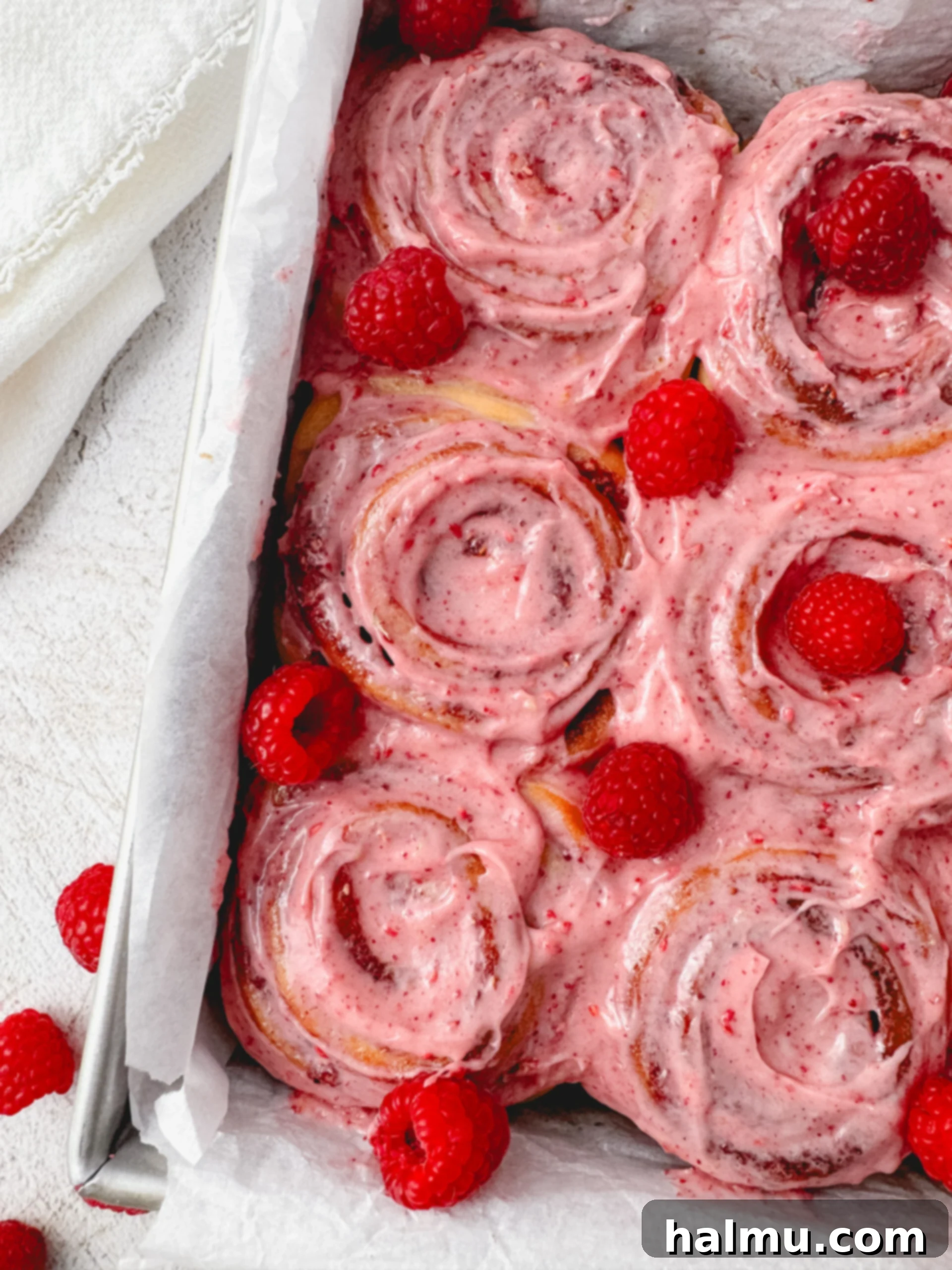 Luscious Raspberry Swirls 7 Freshly frosted Raspberry Sweet Rolls on a cooling rack