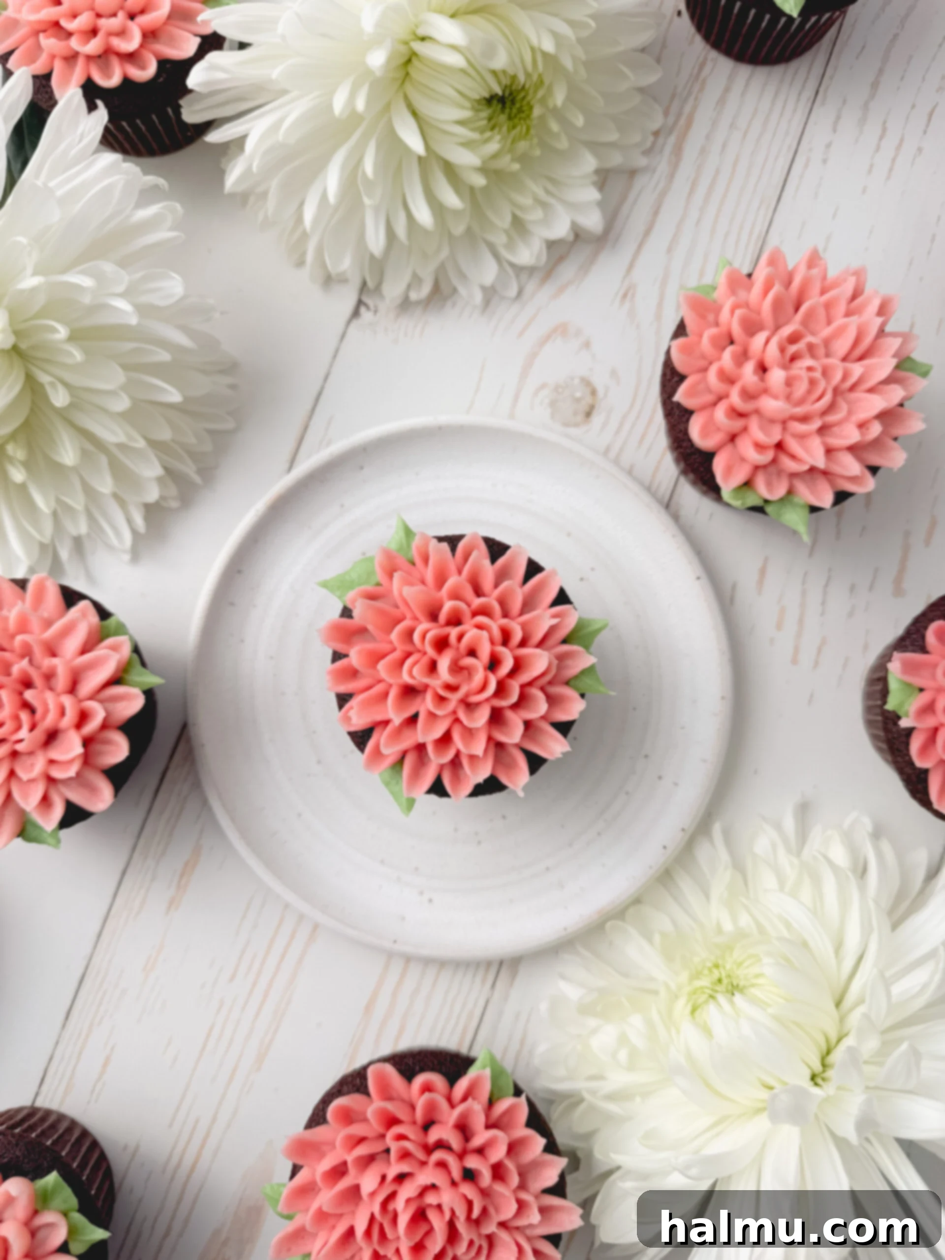 Cupcake Candles 10 A close-up of a fully decorated chocolate mum cupcake with two-toned pink buttercream flowers and green leaves, ready to be served.