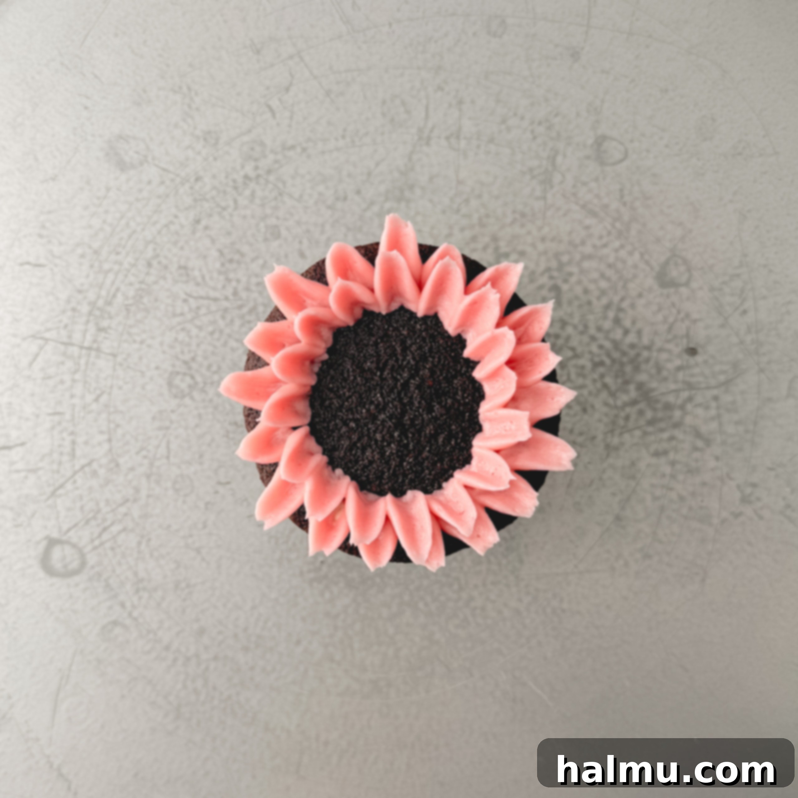 Cupcake Candles 6 A cupcake with two overlapping rings of pink buttercream petals already piped, demonstrating the layering technique for the mum flower.