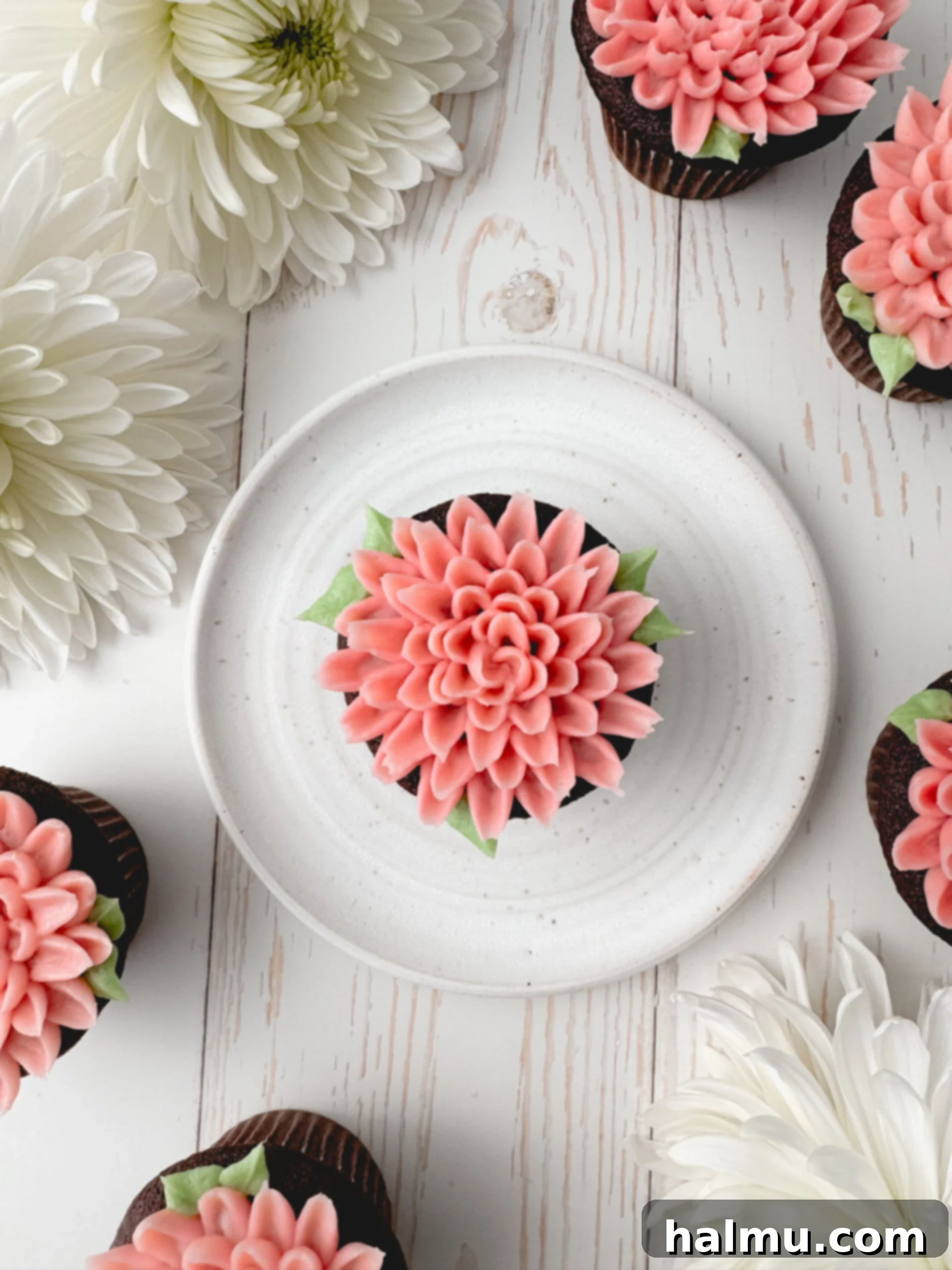 Cupcake Candles 8 A finished mum cupcake, showing the vibrant green buttercream leaves piped around the base of the pink flower, adding a final touch of realism.