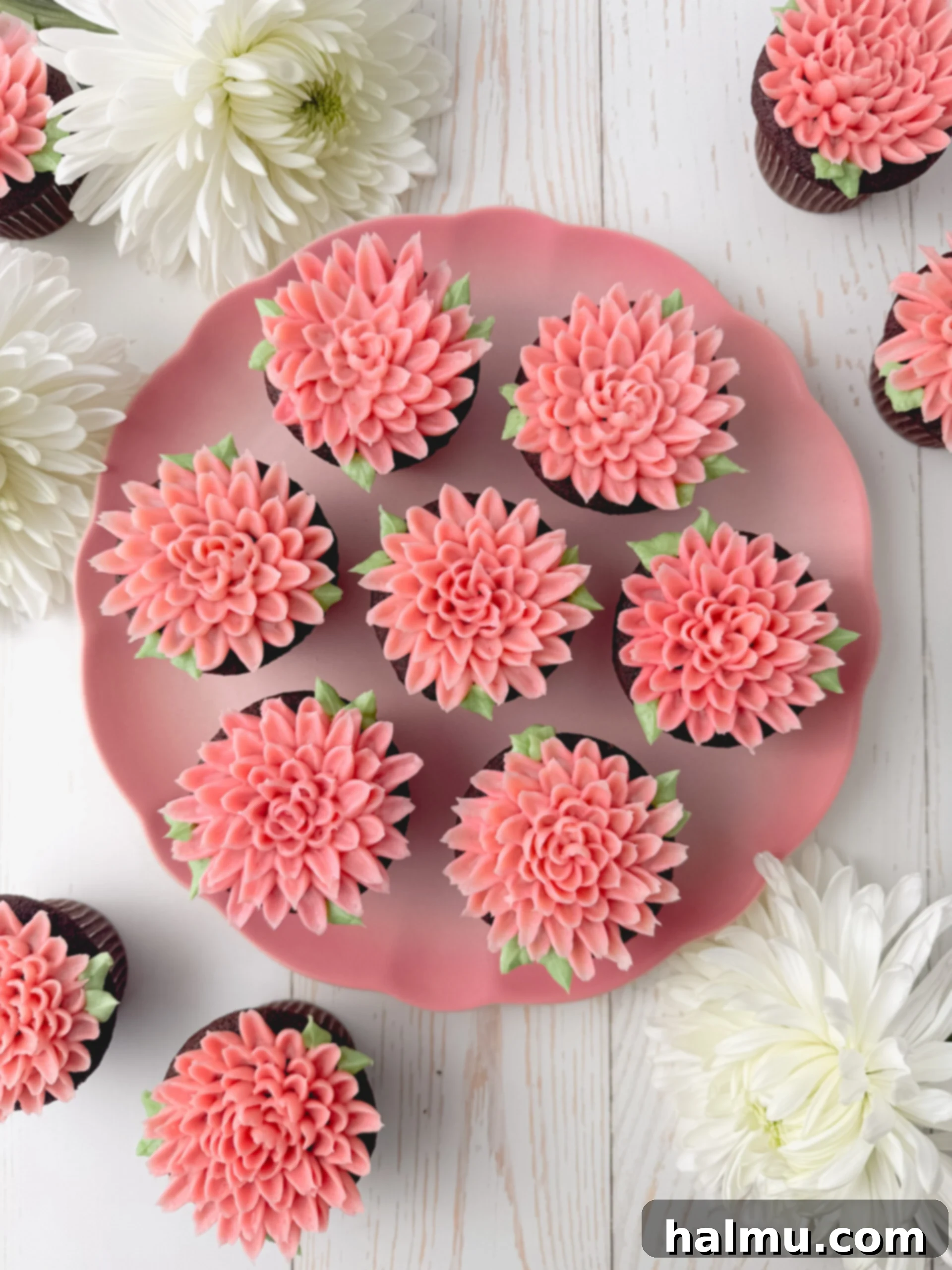 Cupcake Candles 9 A close-up shot of a perfectly piped pink and green buttercream mum cupcake, highlighting the smooth texture and intricate details of the frosting.