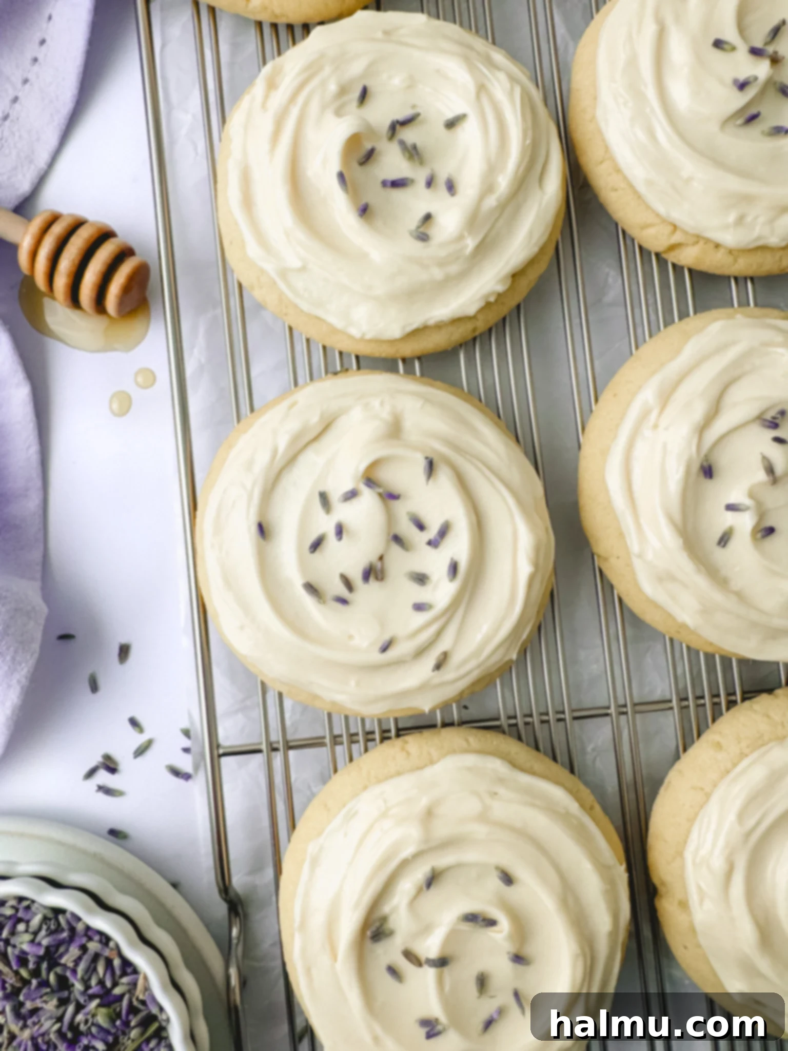 Lavender Kissed Honey Cookies 2 Close-up of a stack of Honey Lavender Cookies with creamy frosting and lavender buds.