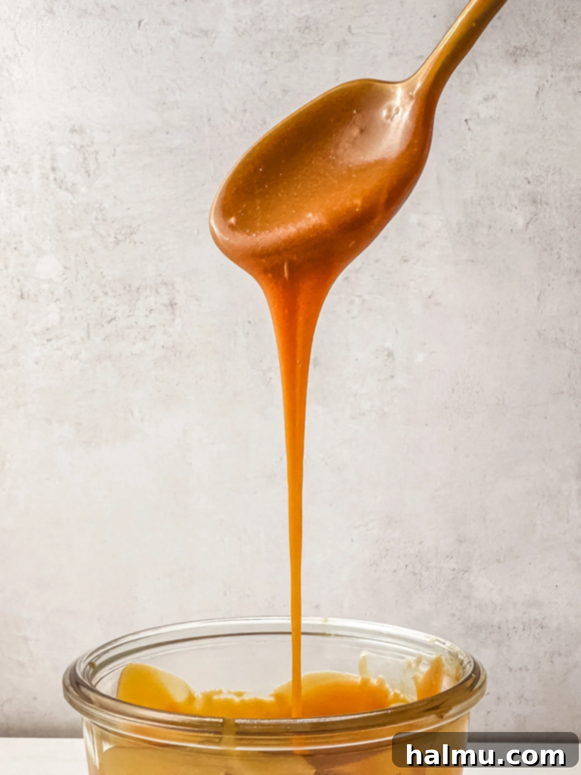 Close-up of golden homemade caramel in a glass jar