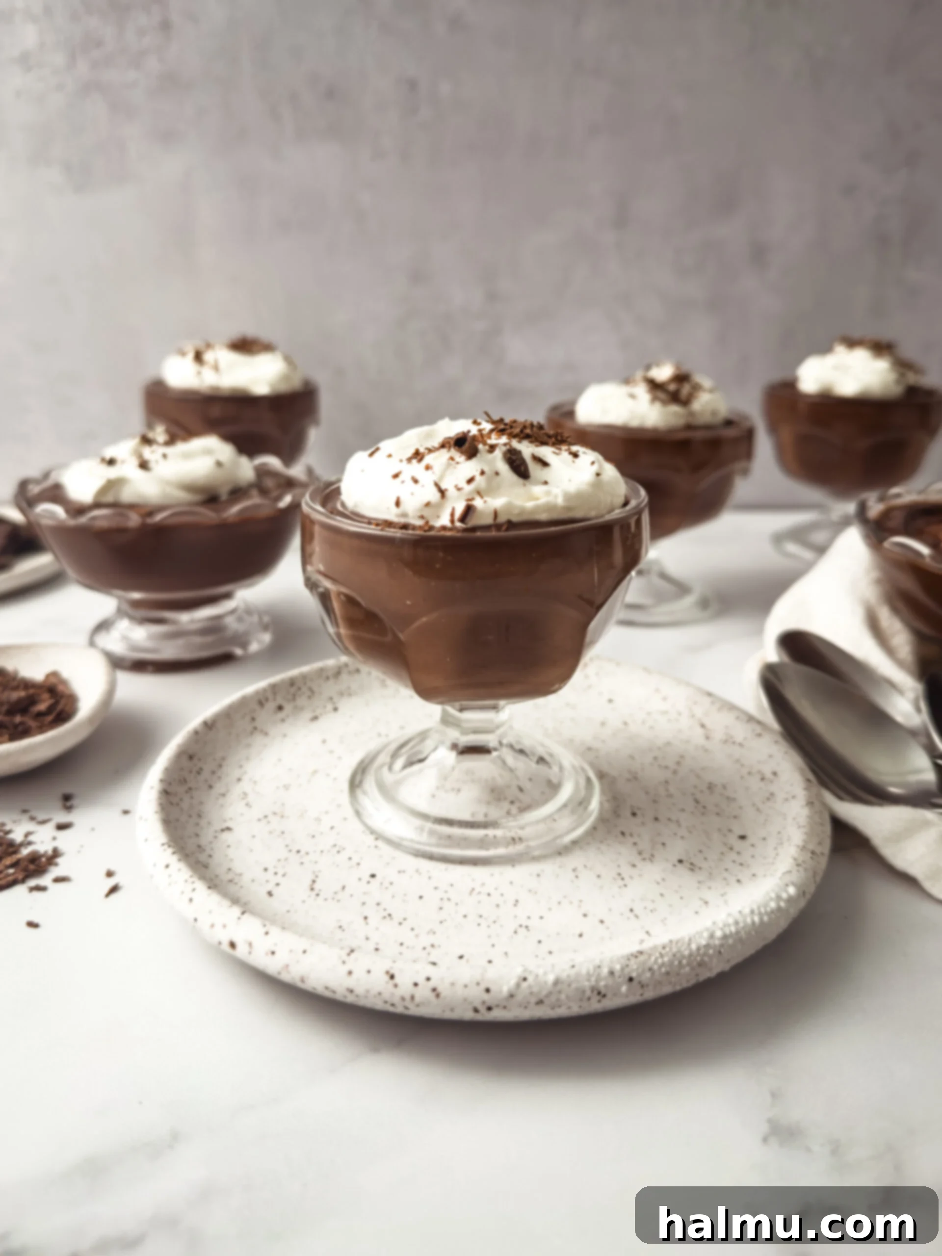 Delicious homemade chocolate pudding in a glass cup, topped with whipped cream and chocolate shavings.