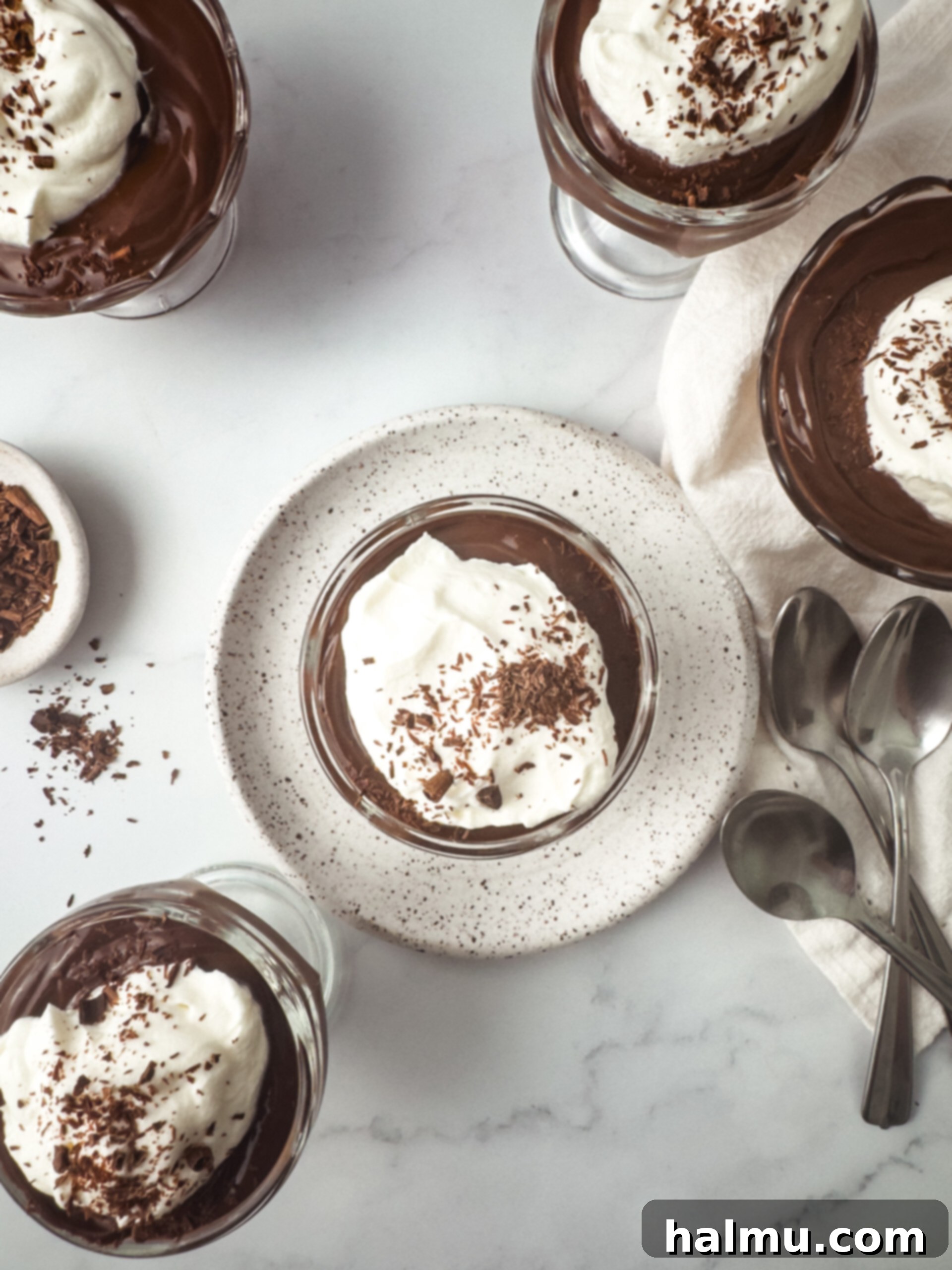 Ingredients for homemade chocolate pudding laid out on a wooden table, ready for preparation.
