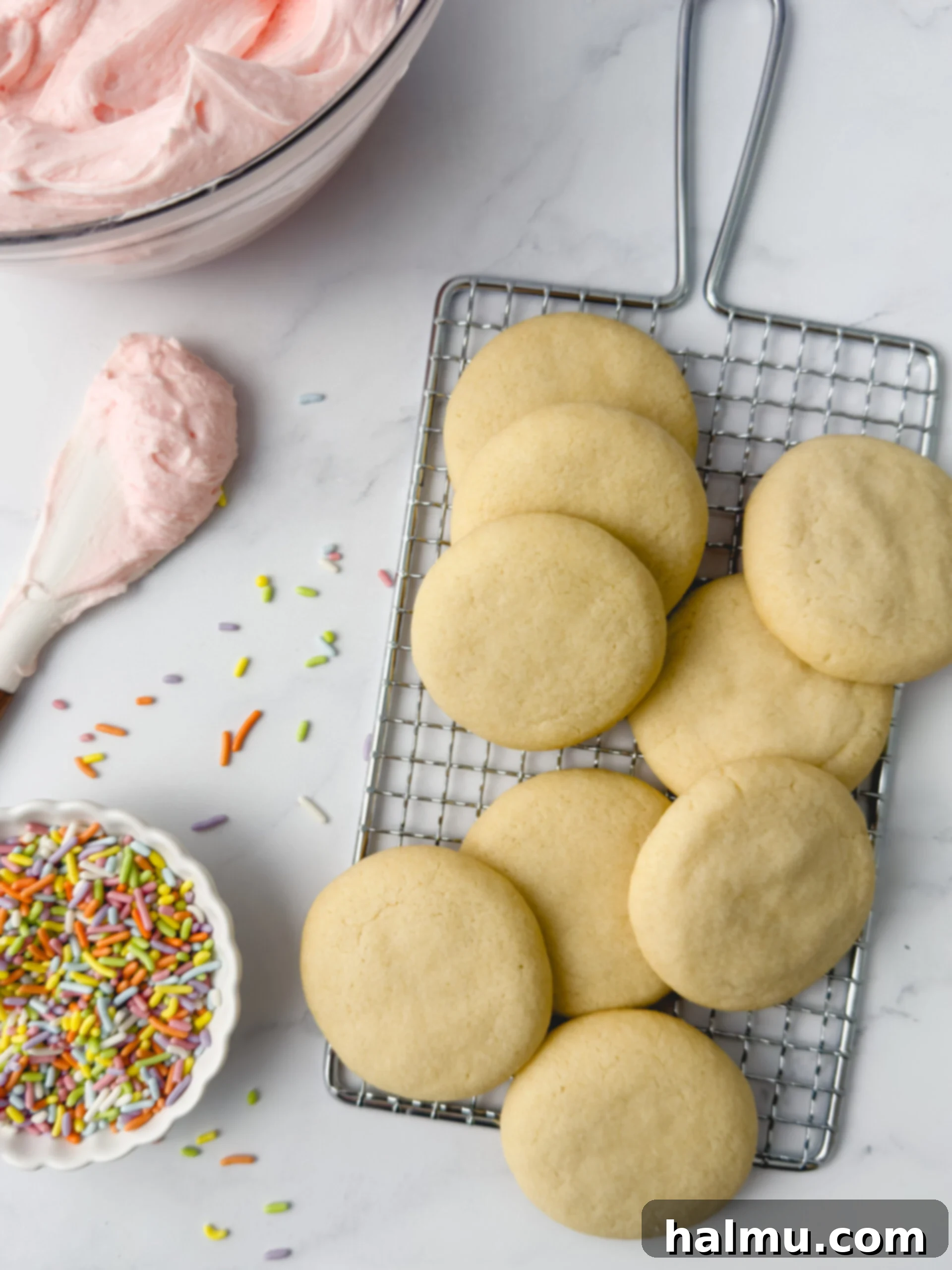 Piping vanilla buttercream onto mini sugar cookies.