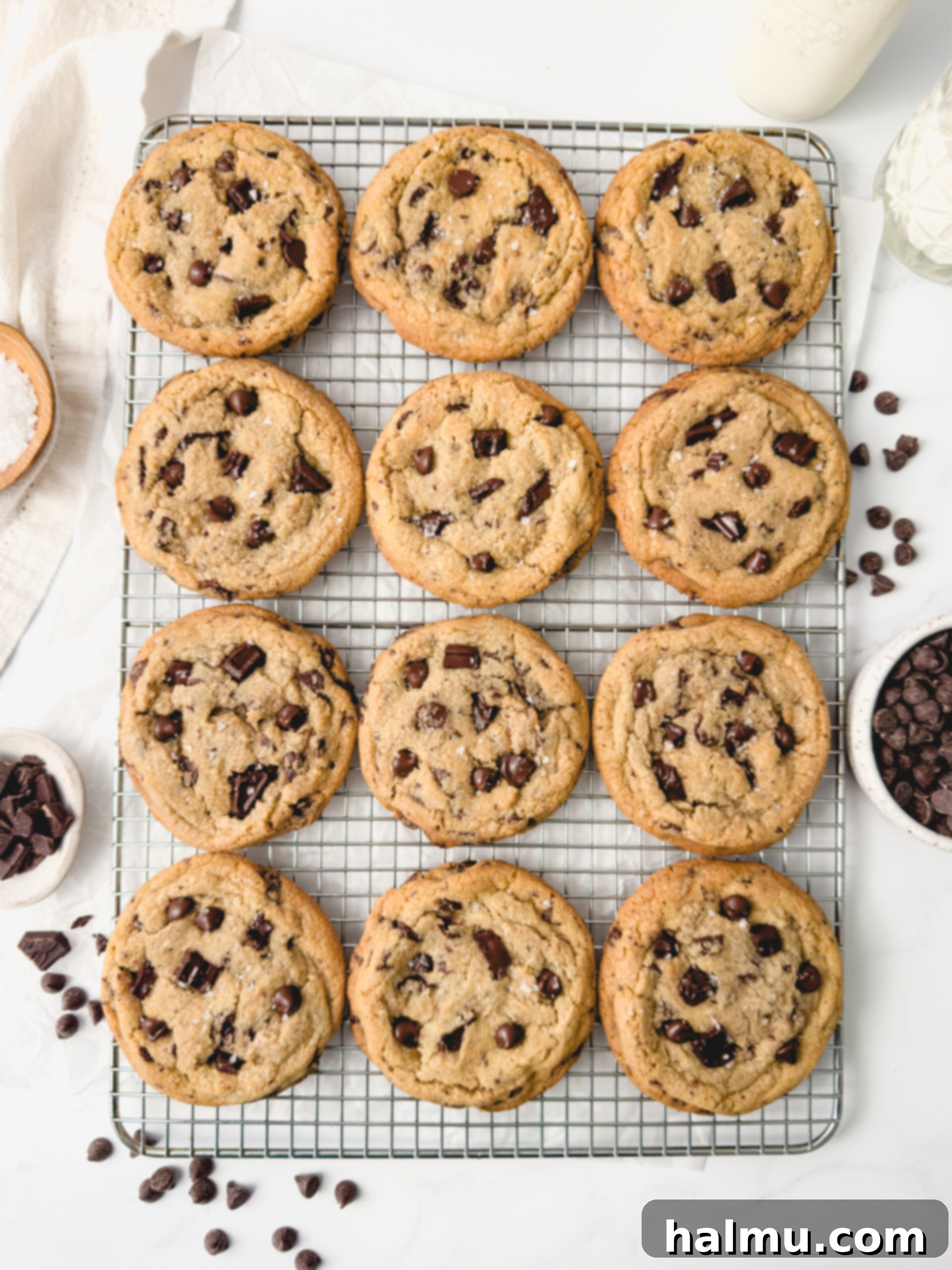 A stack of warm chocolate chip cookies with flaky sea salt.