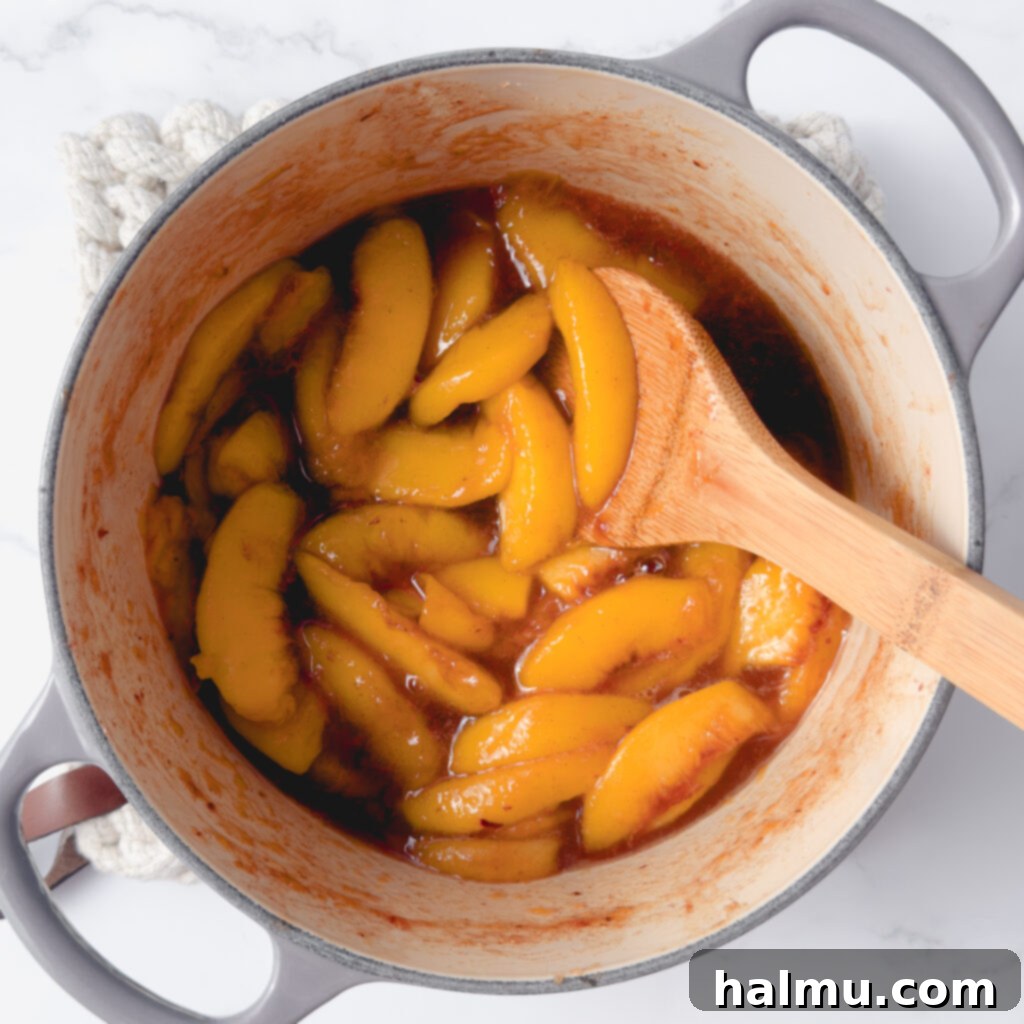 Peach Shortcake 4 Sliced peaches simmering in a saucepan for compote.