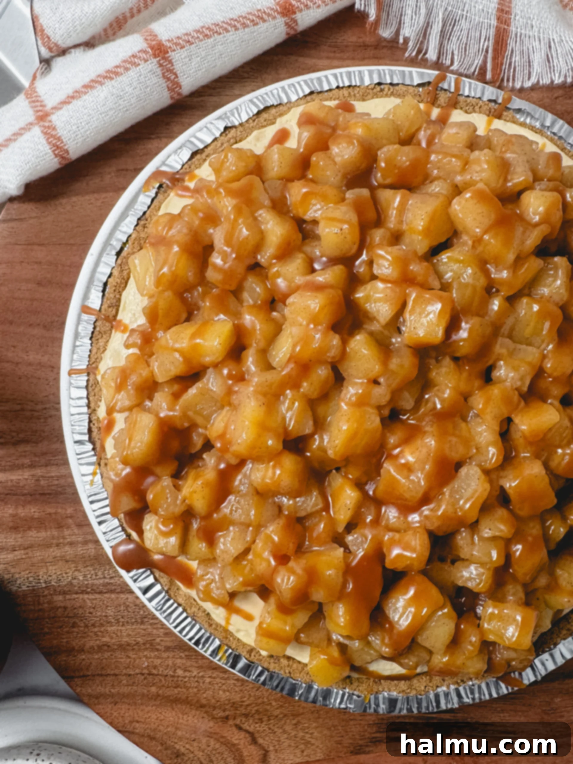 Top-down view of the Caramel Apple Cheesecake Pie, showcasing the caramel drizzle over the apple compote.