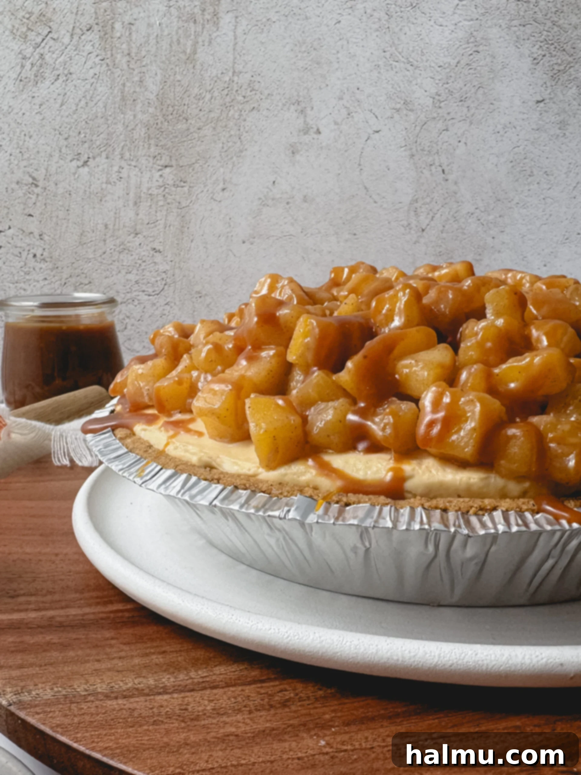 A slice of Caramel Apple Cheesecake Pie, showing a thick layer of apple compote over the cheesecake.