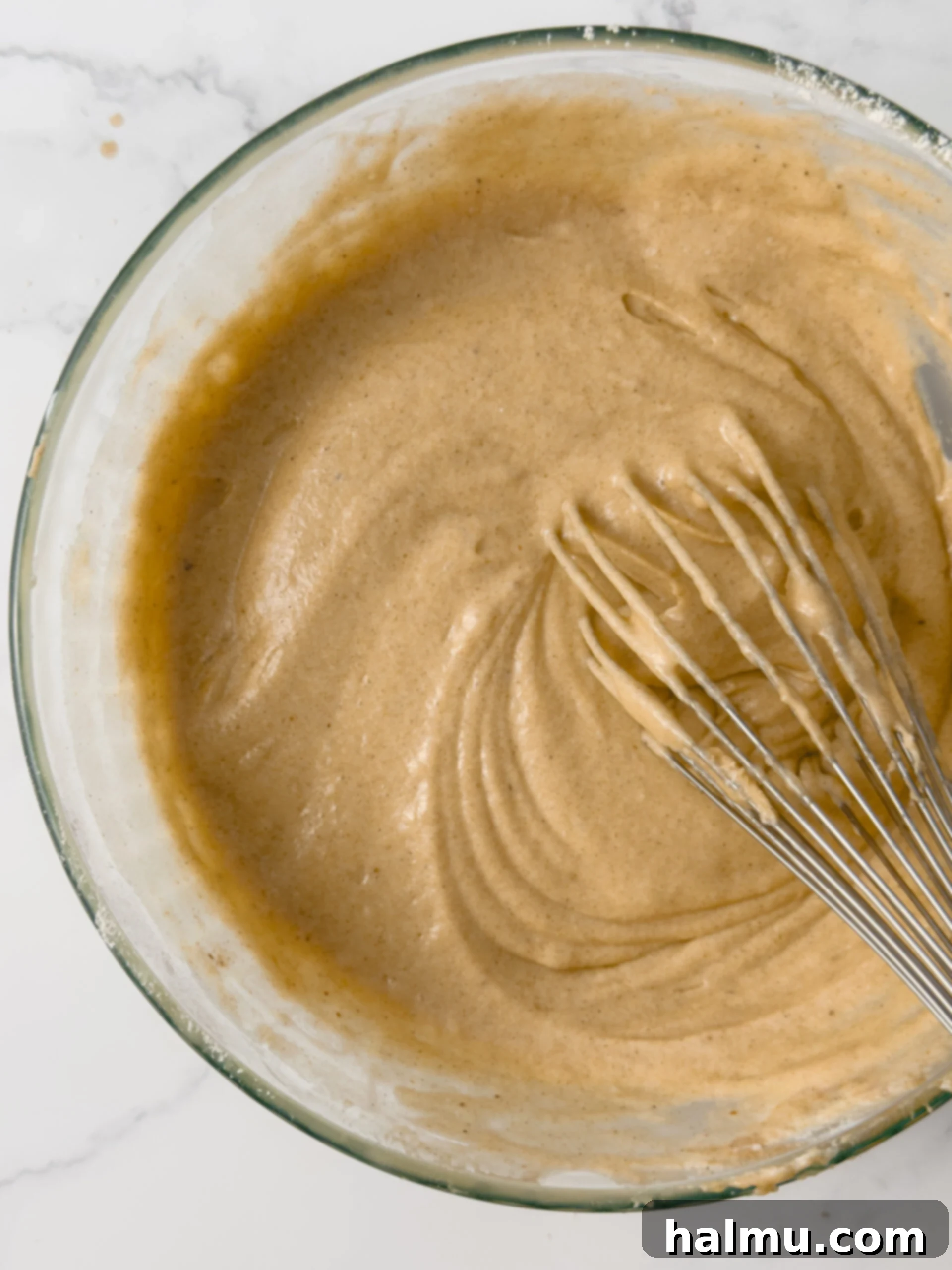 Spiced Apple Cider Doughnut Loaf 4 The process of mixing the wet ingredients, including melted butter and sugars, for the Apple Cider Donut Loaf Cake batter.