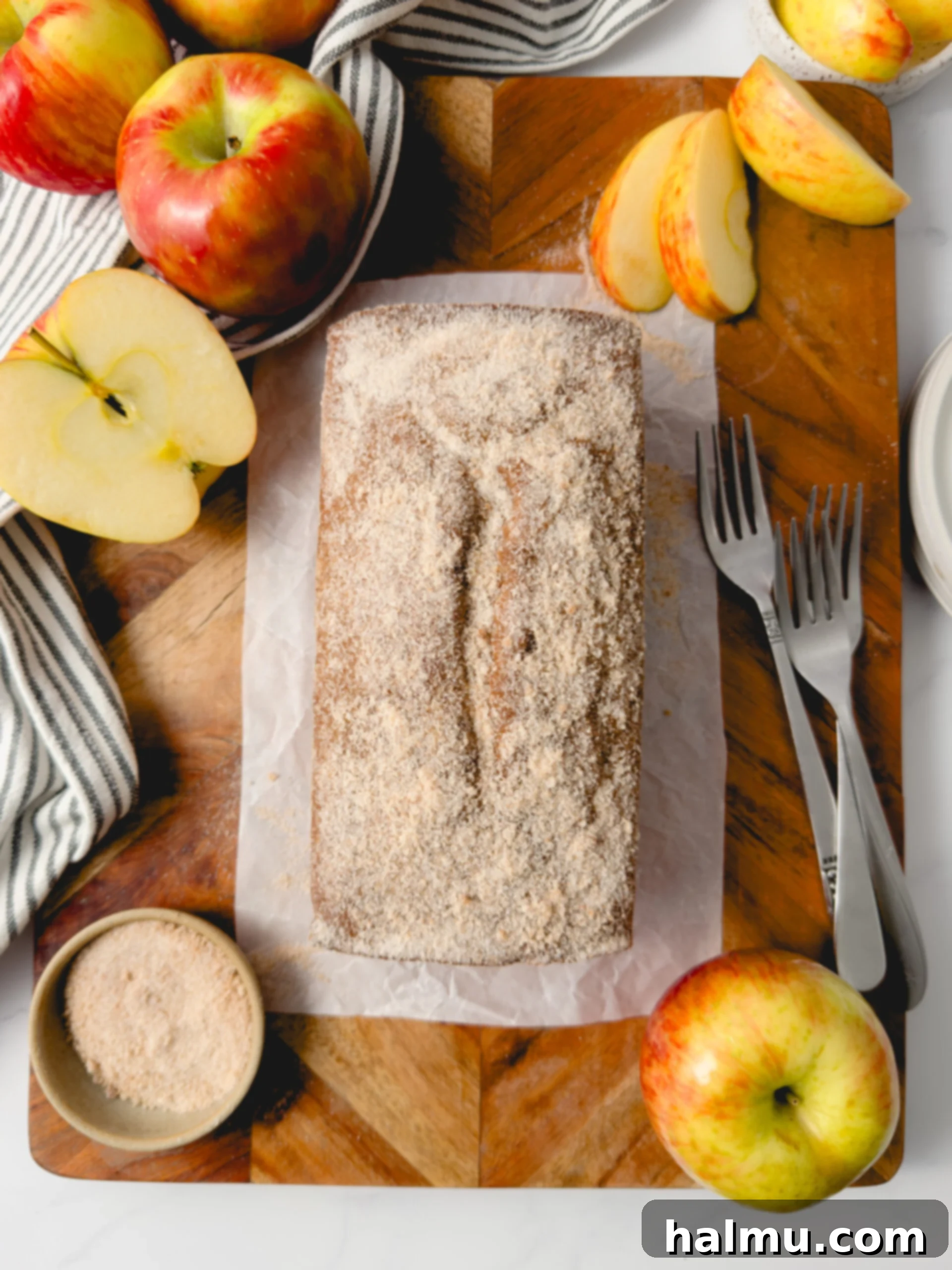 Spiced Apple Cider Doughnut Loaf 6 A perfect slice of Apple Cider Donut Loaf Cake, showcasing the tender interior and a generous layer of cinnamon sugar on top, served on a white plate.