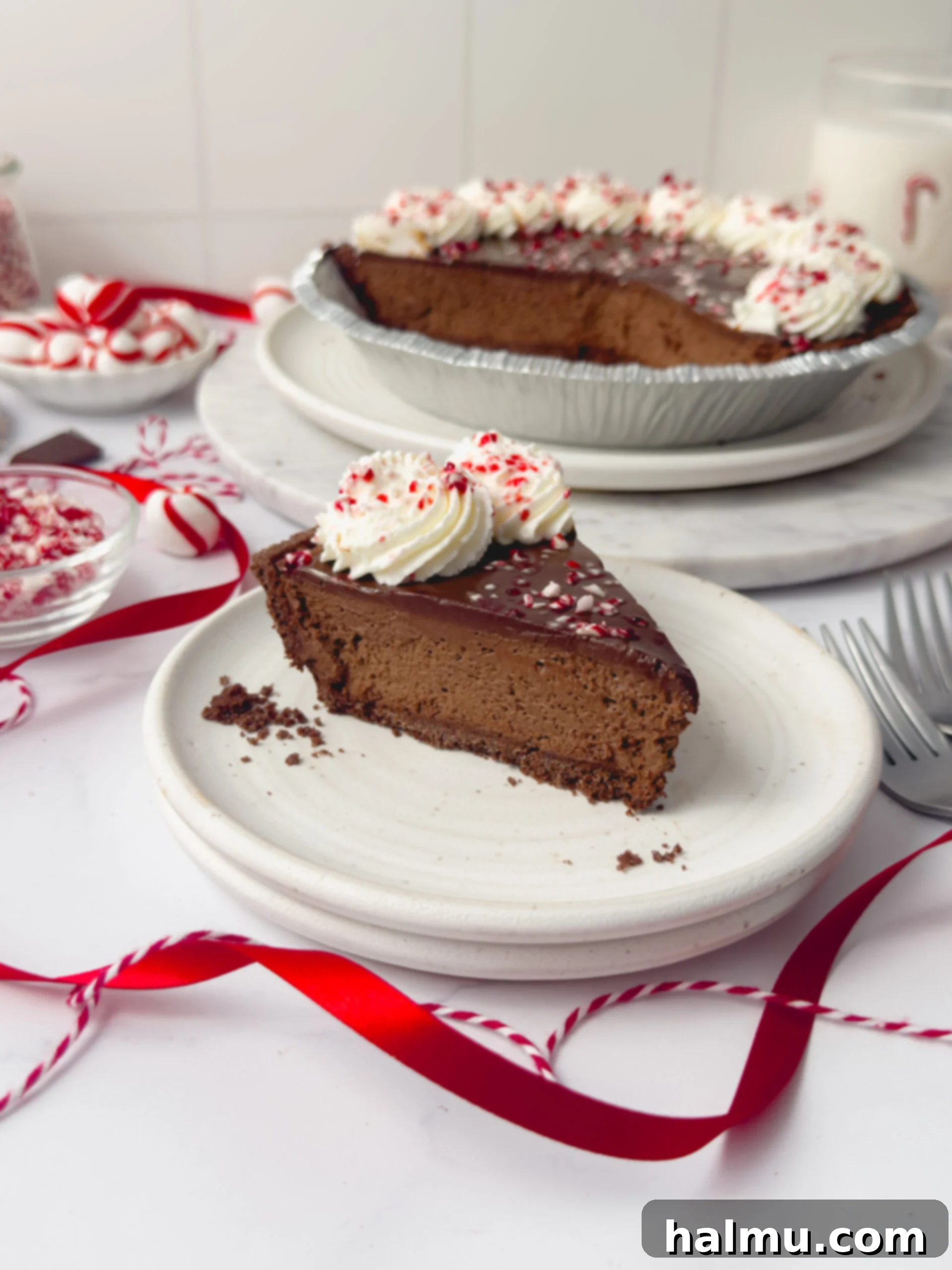 Decadent Chocolate Peppermint Dream 2 A beautifully sliced Chocolate Peppermint Pie, showcasing its distinct layers of chocolate cookie crust, silky chocolate peppermint mousse, rich ganache, and fluffy whipped cream, adorned with crushed candy canes.