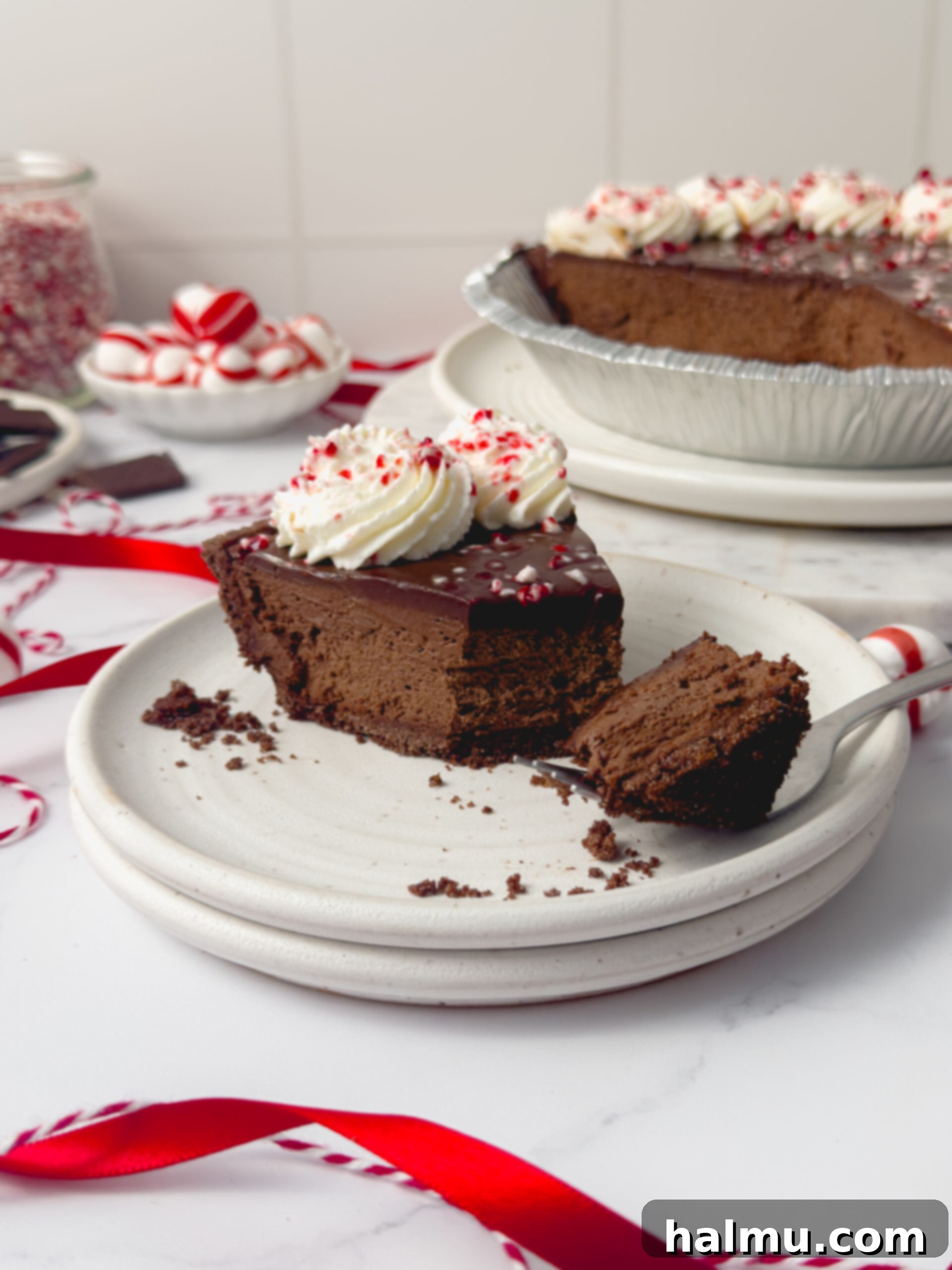 Decadent Chocolate Peppermint Dream 6 A slice of Chocolate Peppermint Pie on a plate, with a spoon taking a bite, showing the creamy layers.