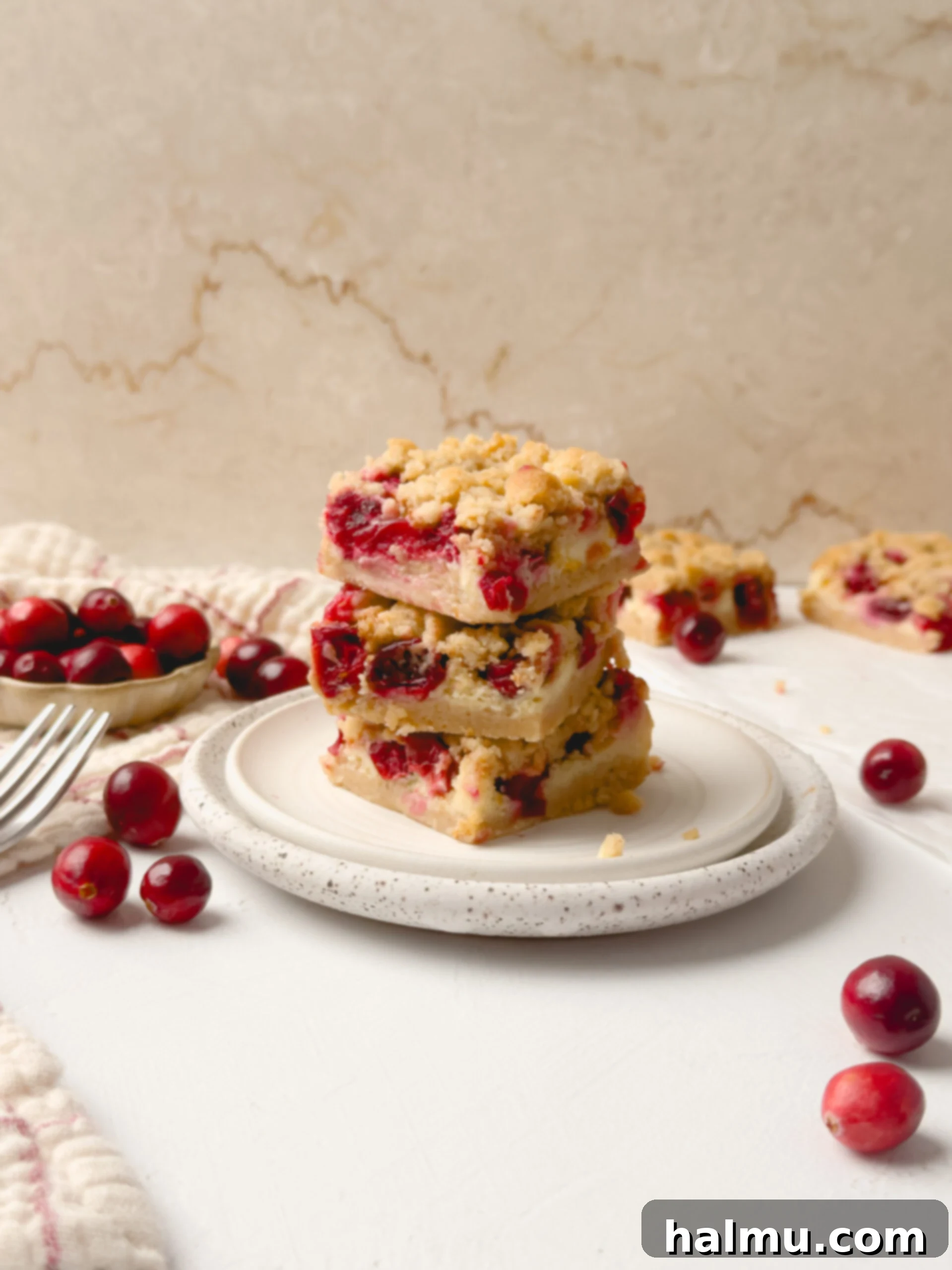 Perfectly sliced cranberry cheesecake bars on a cutting board, ready to serve.