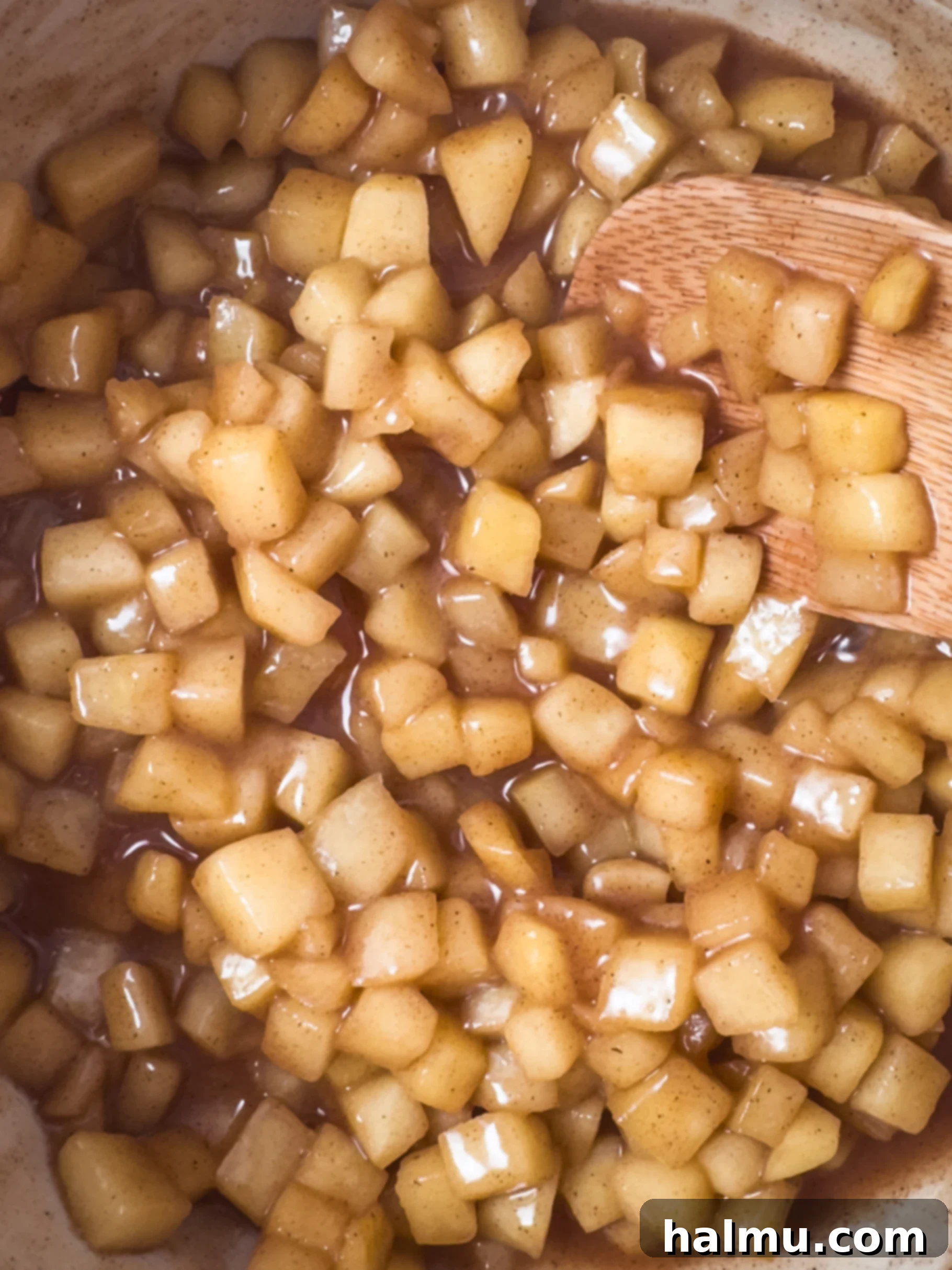 Warm apple compote in a bowl with a spoon