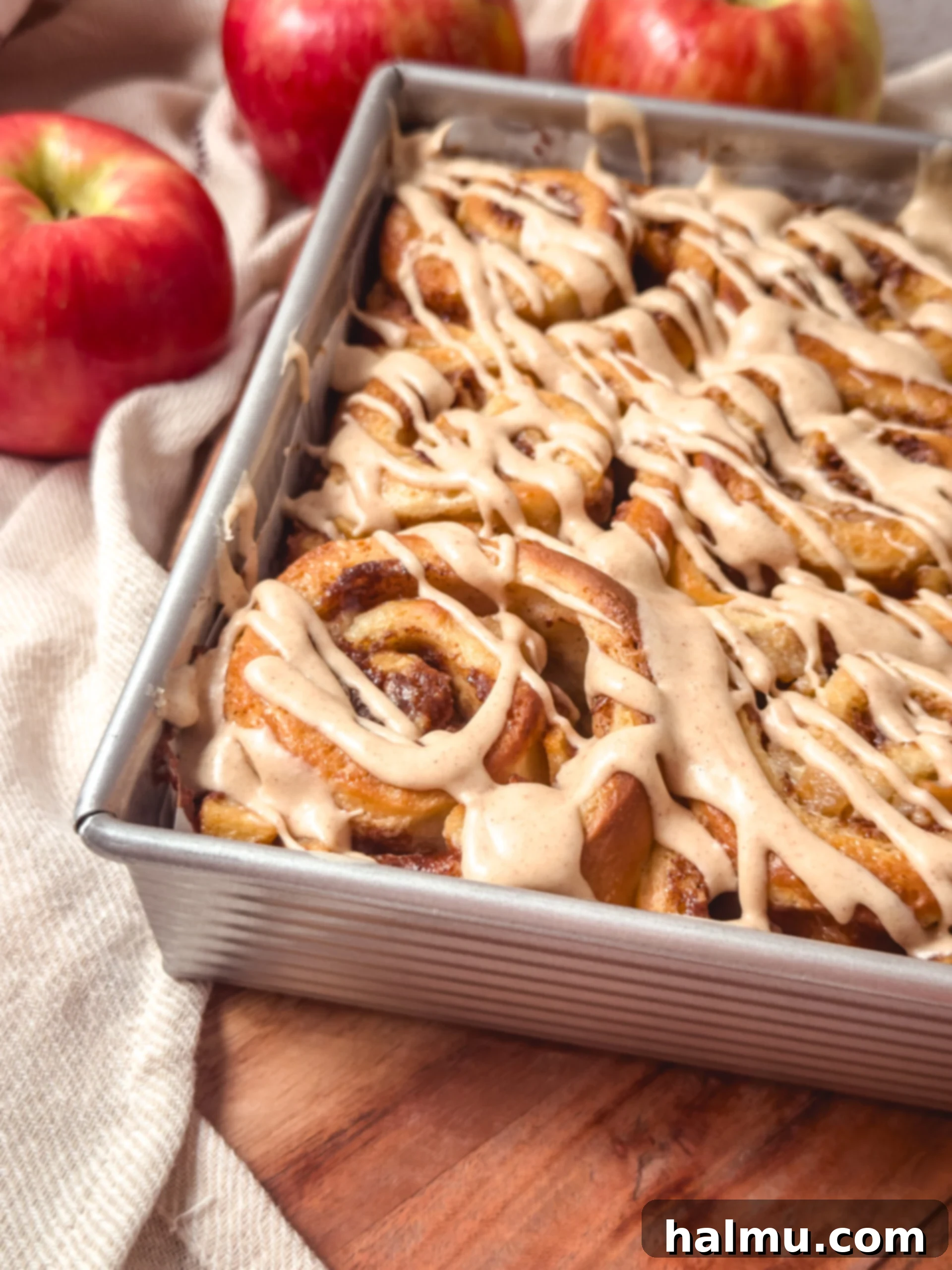 Orchard Apple Cinnamon Swirls 6 Close-up of a warm, glazed apple pie cinnamon roll