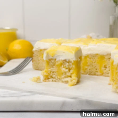 A square Lemon Curd Cake with white frosting and lemon swirls.
