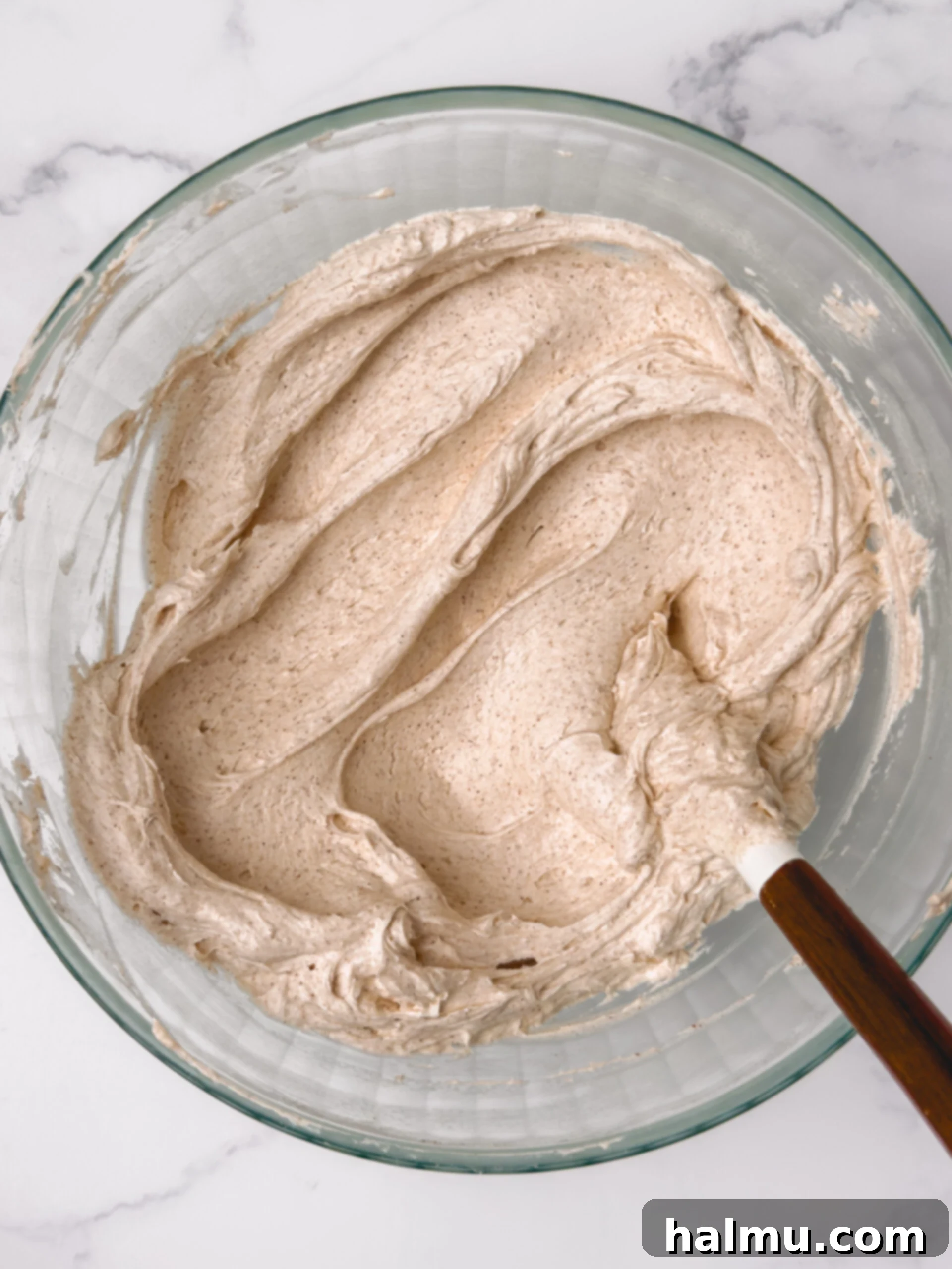Freshly frosted churro cookies with a sprinkle of cinnamon sugar on top, ready to be served.