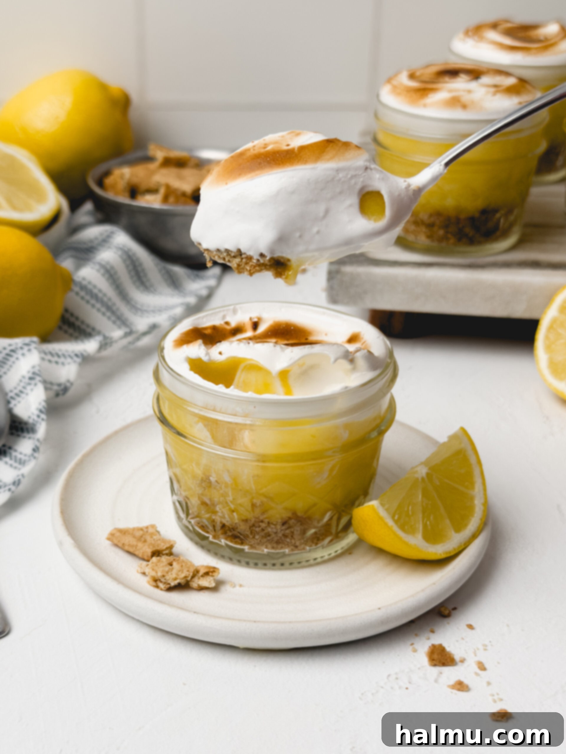 Overhead view of two Lemon Meringue Pie Cups with vibrant yellow lemon curd and white meringue.