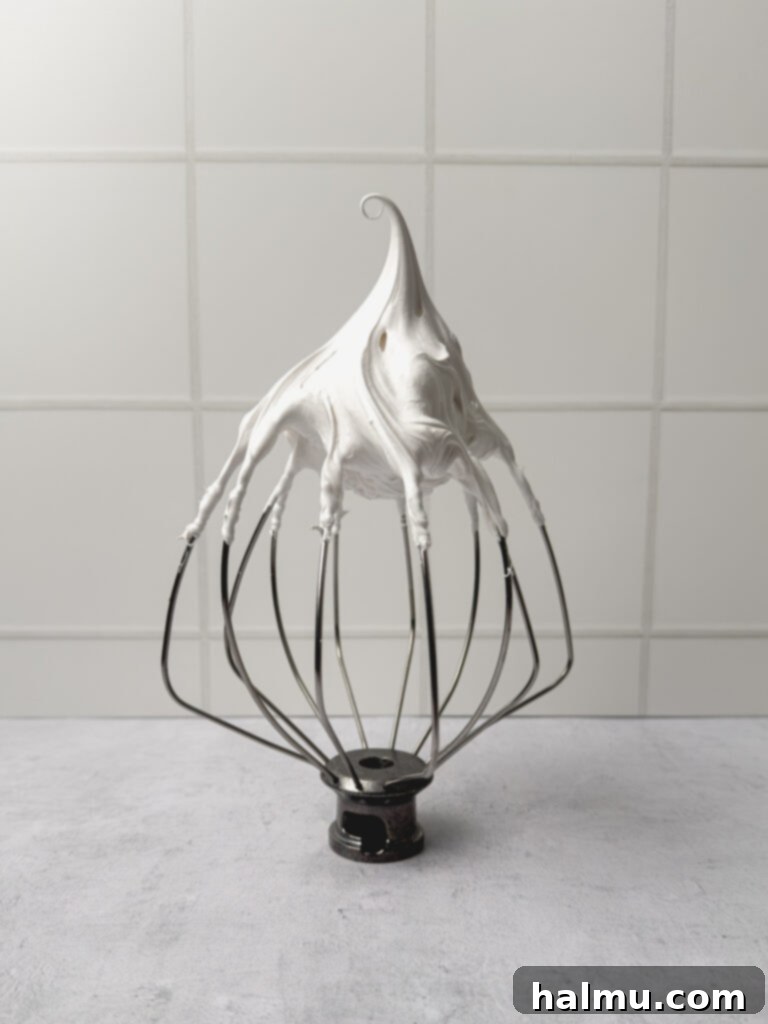 A kitchen torch caramelizing the meringue topping on a lemon meringue pie cup.