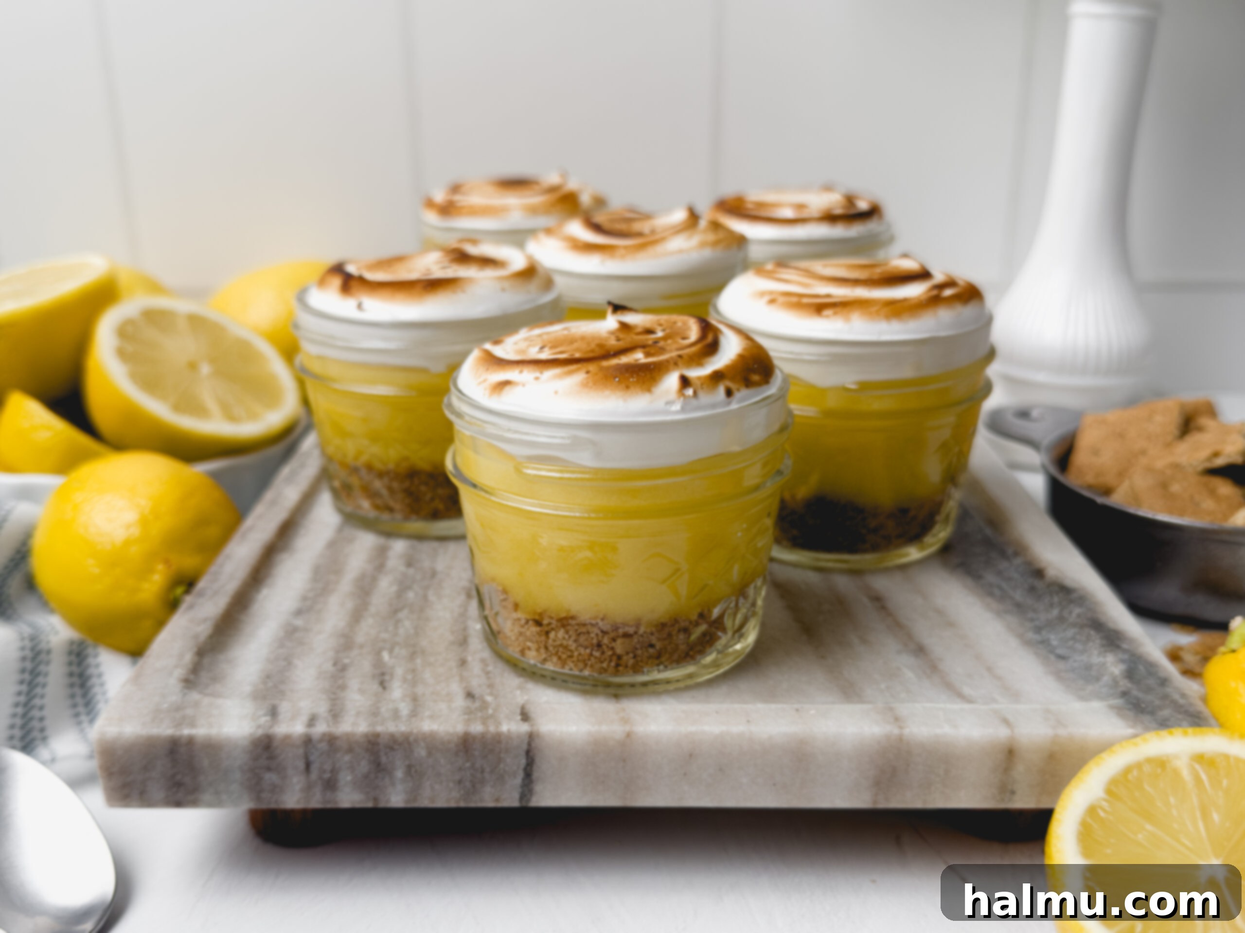 Six Lemon Meringue Pie Cups arranged on a platter, ready to be served.