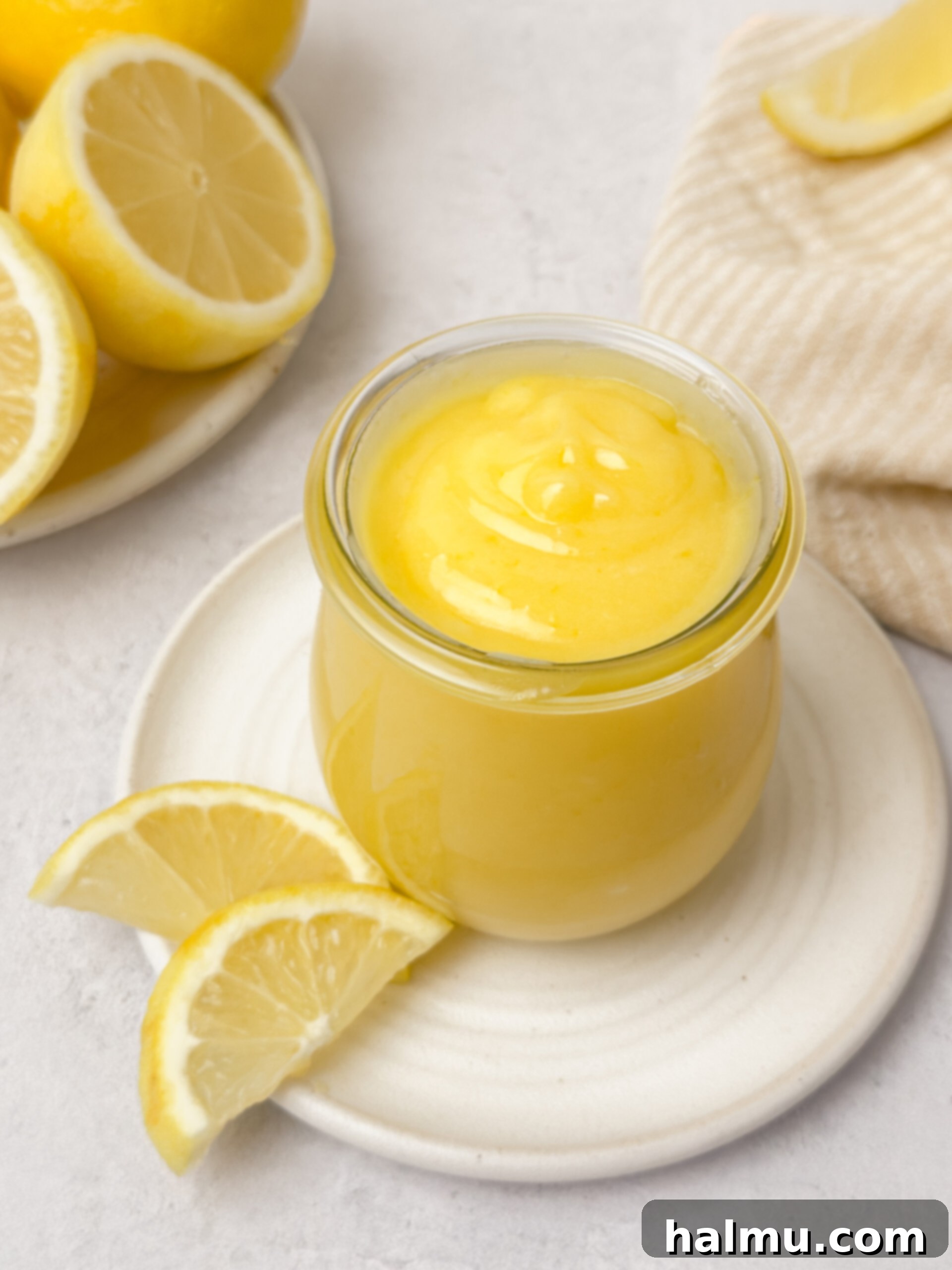 Zesty Lemon Cream 3 A close-up shot of creamy lemon curd being stirred in a bowl, highlighting its smooth, glossy texture and bright yellow color.