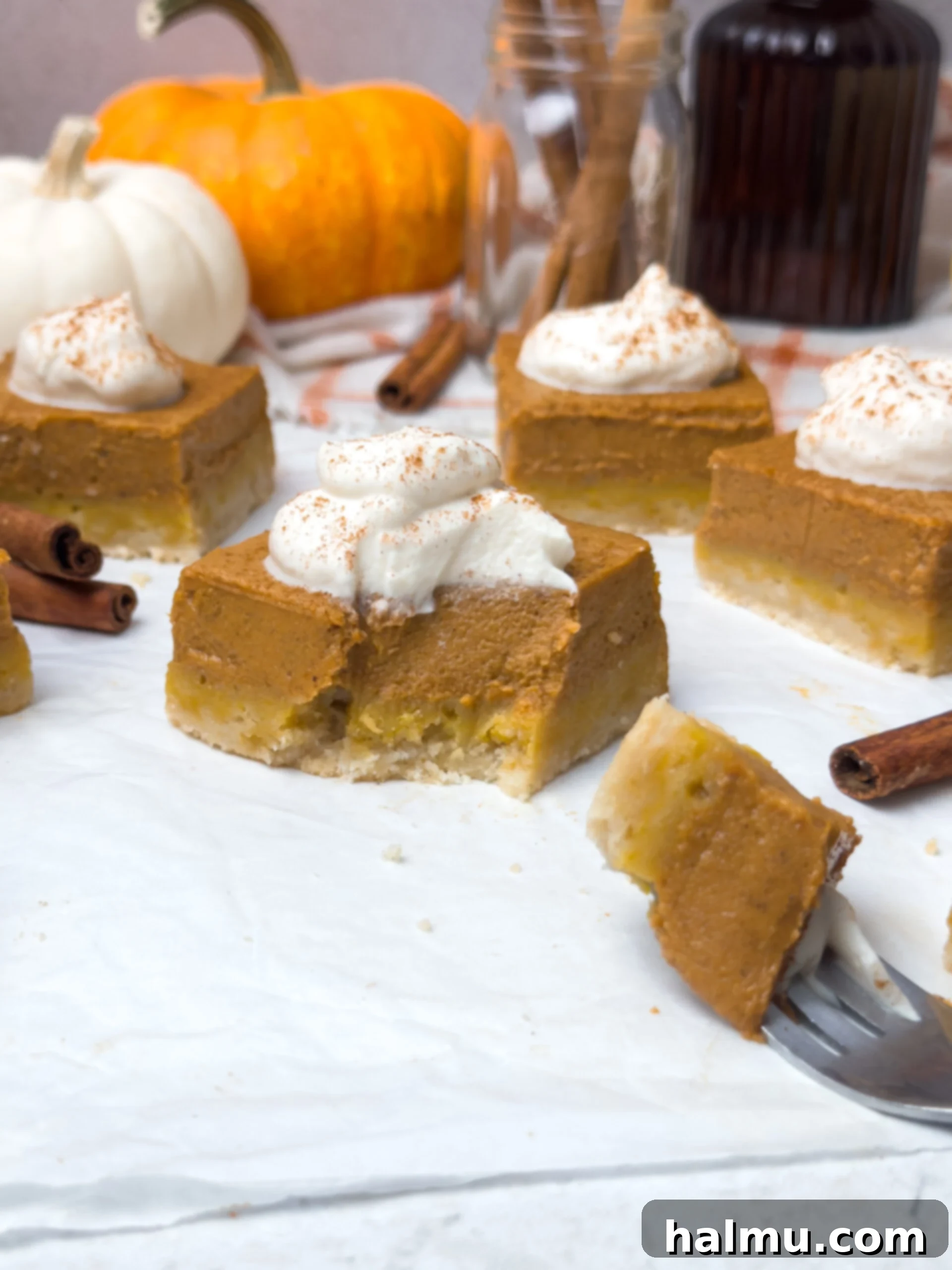 An overhead shot of several pumpkin pie bars with a single slice removed, indicating their readiness to be eaten.