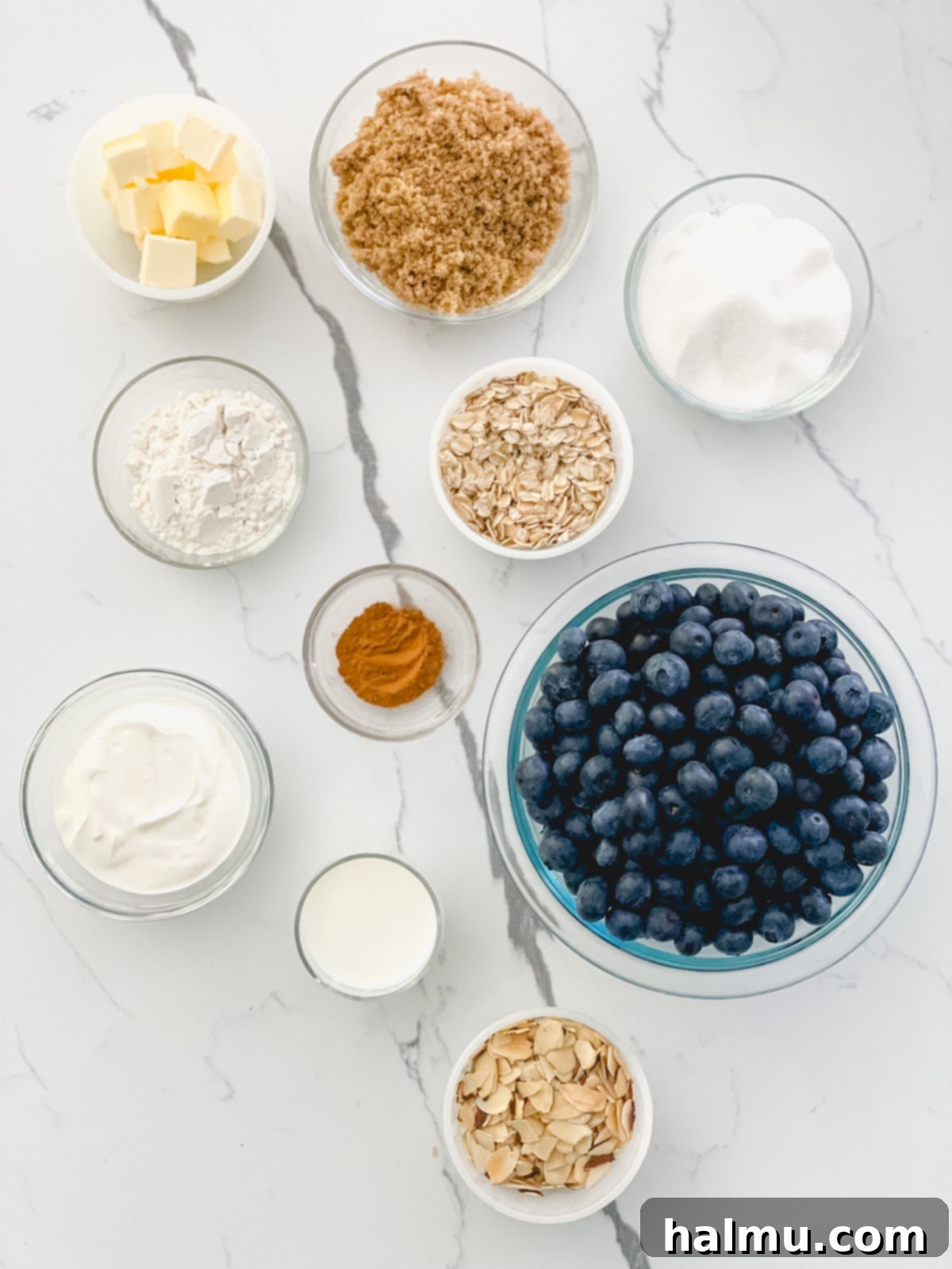 Ingredients for the Blueberry Almond Skillet Crisp neatly arranged, showcasing fresh blueberries, oats, butter, and other baking essentials.